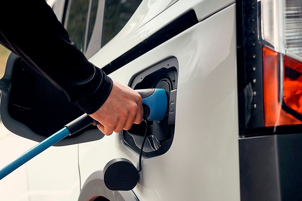 Uma pessoa que liga um veículo elétrico Ford a um cabo de carregamento de veículos elétricos.