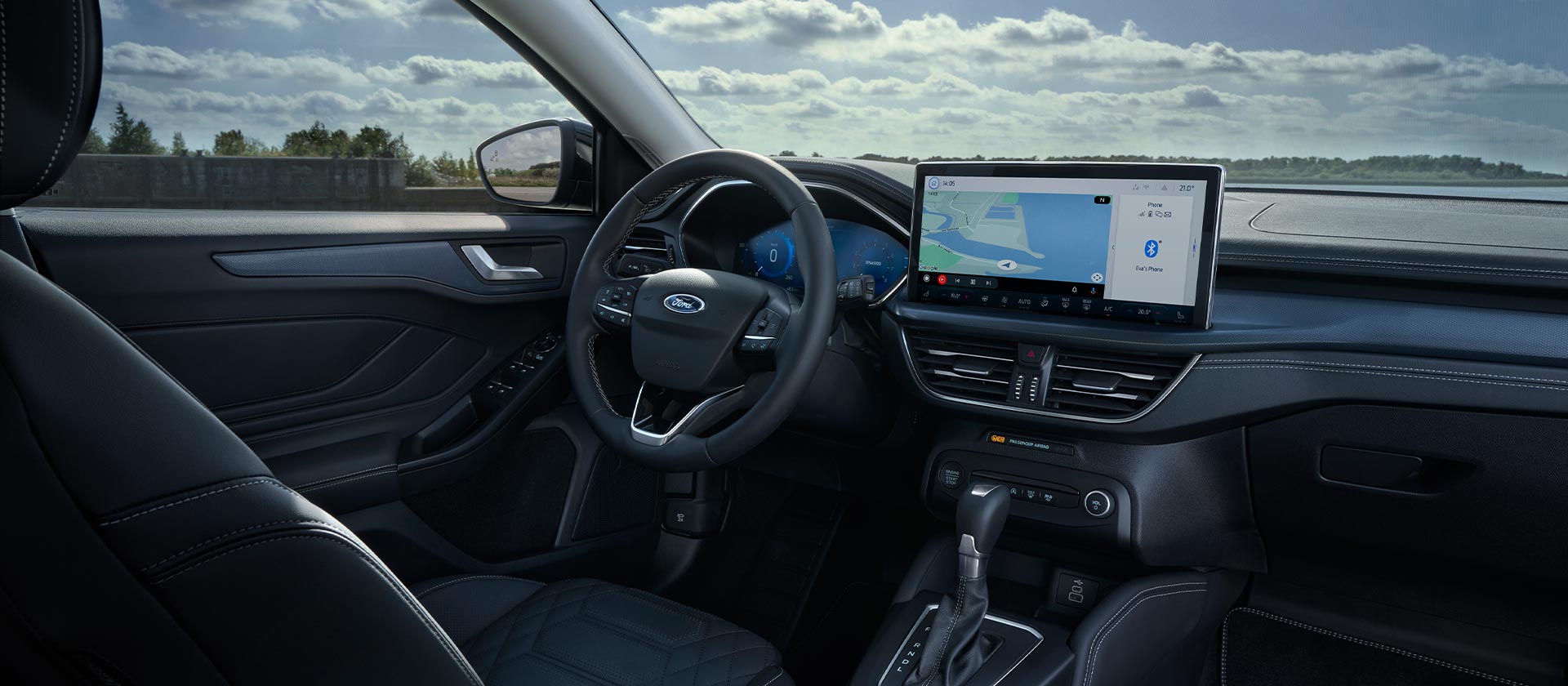 Vista interior do Ford Focus, mostrando o painel de instrumentos, ecrã de infoentretenimento com navegação e volante.