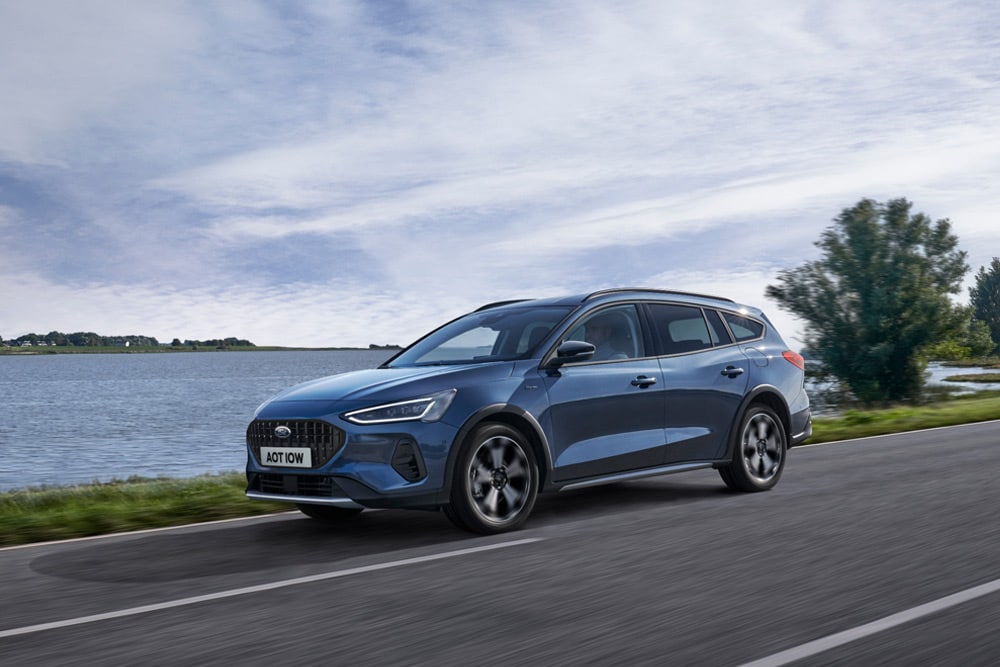 Ford Focus® Estate azul a passar junto a um lago.