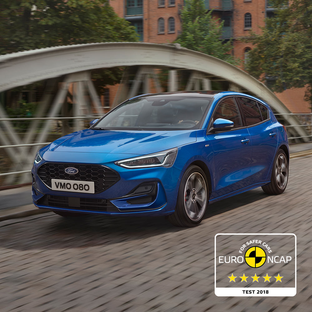 Um Ford Focus azul estacionado numa ponte, com o emblema de classificação de segurança Euro NCAP de cinco estrelas no canto inferior direito.