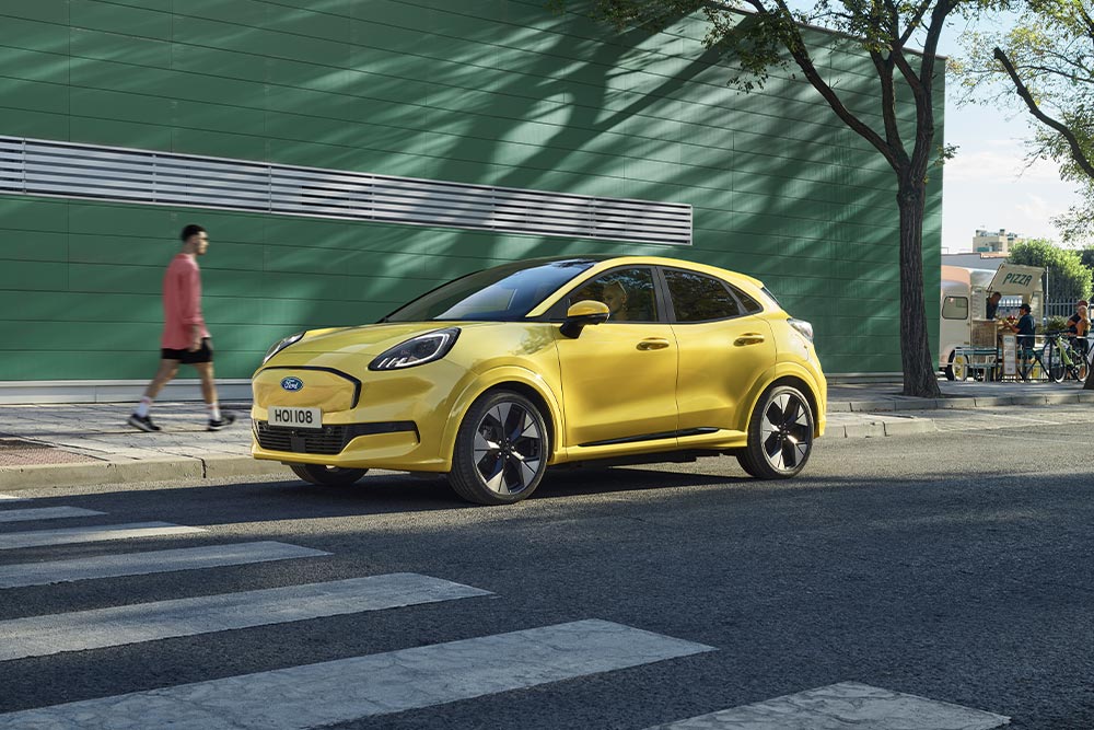 1000x1000 image of a grey Puma Gen-E parked on a main road.