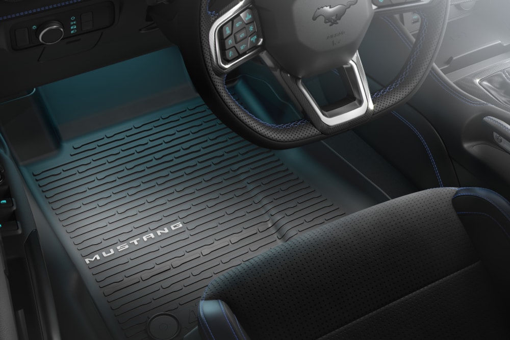 Vista interior de um Ford Mustang, onde se pode ver o volante e um tapete.