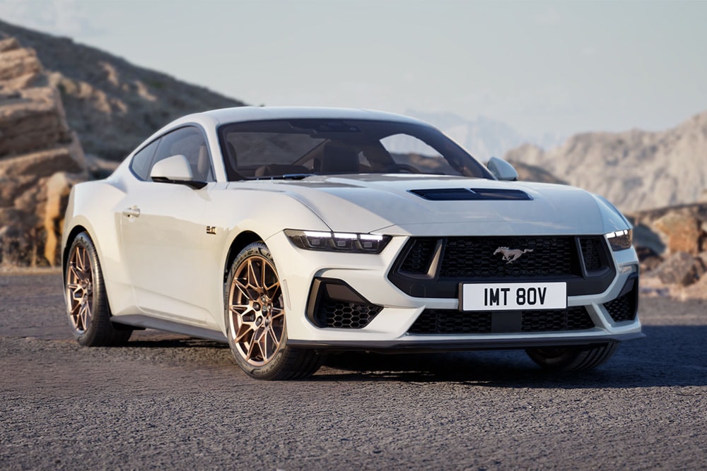 Ford Mustang GT Fastback com Bronze Pack na cor Oxford White estacionado numa estrada de montanha