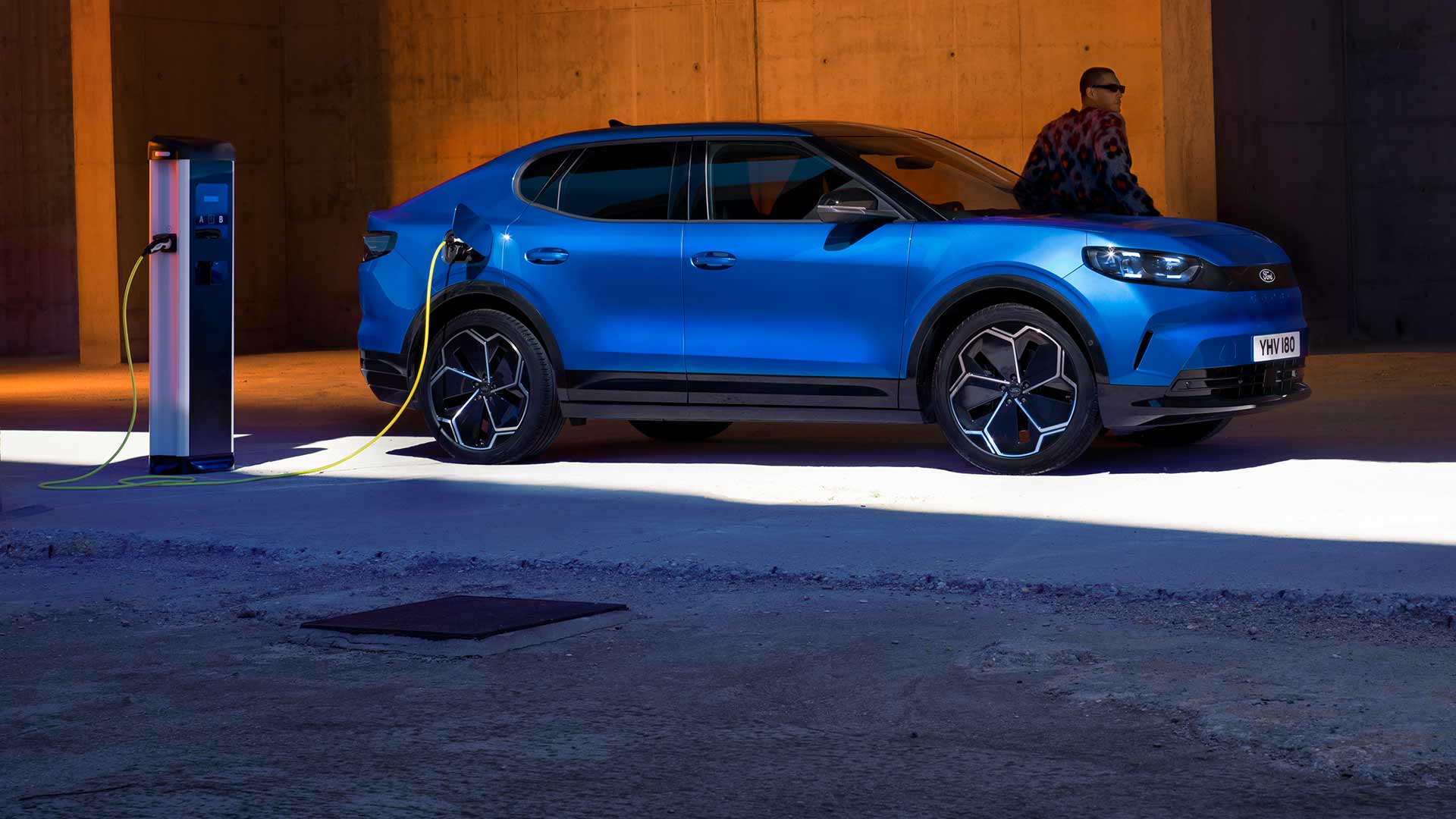 Blue electric Ford Capri® plugged into a public EV charging point.