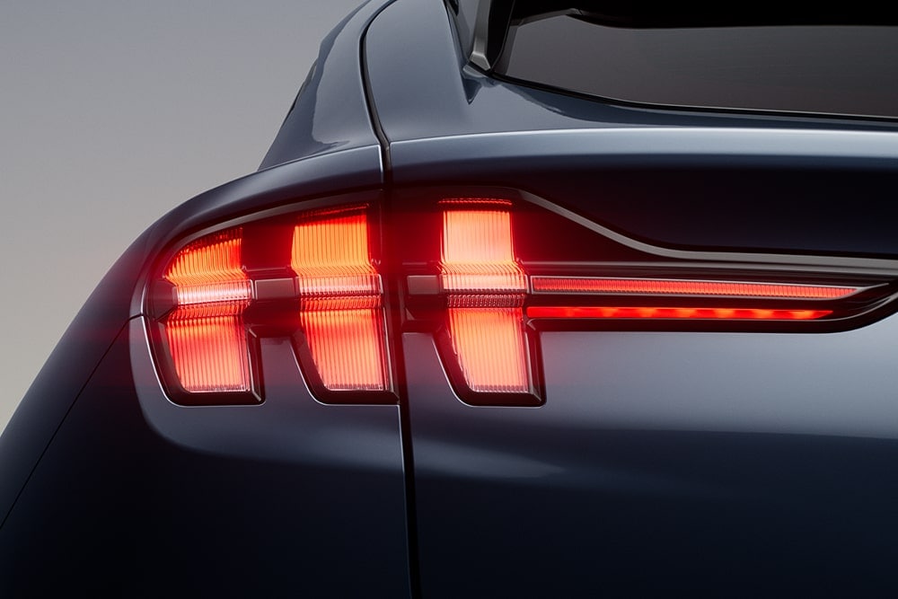 Grande plano das luzes traseiras triplas acesas num do Ford Mustang Mach-E.