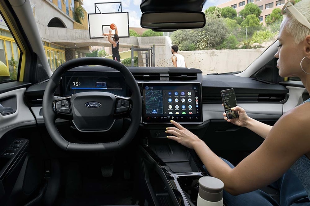 Interior do carro pequeno Ford Puma Gen-E, que mostra os controlos no ecrã tátil.